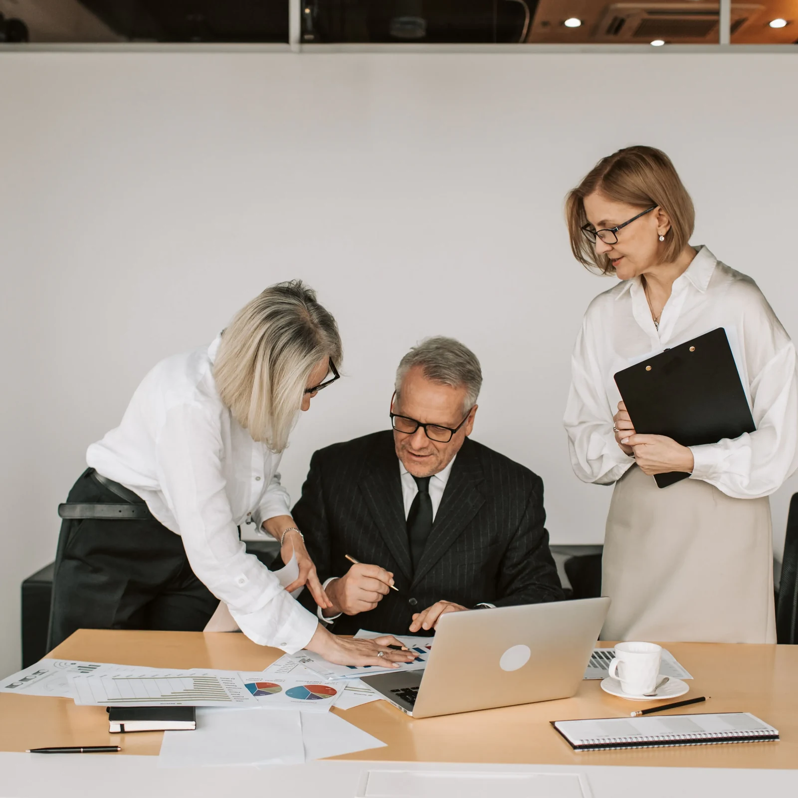 Financial planning review with advisers examining household records and charts